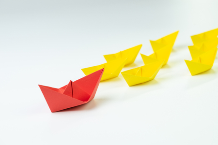 Leadership, influencer, KOL, key opinion leader concept, big red paper ship origami in front of others followers small yellow fleet.の写真素材