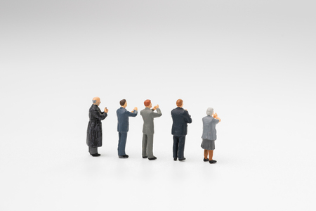 Back view of miniature people happy team member, colleague or audiences clapping appreciating after success in work, reach goal or target or meeting on white background.の写真素材
