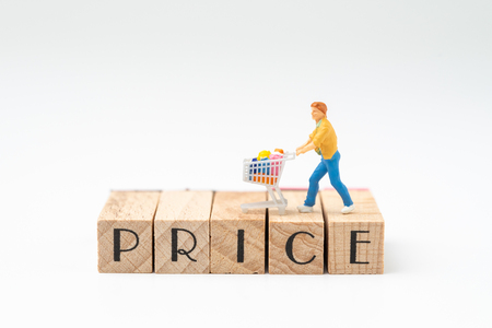 Promotion and pricing for marketing commerce concept, miniature figurine trolly shopping cart with full grocery on wooden stamp building the word PRICE on white background.の写真素材