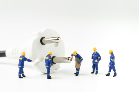 Sustainable energy, power consumption or electricity innovation concept, miniature people worker, technician help fixing or building electricity plug on white background with copy space.の写真素材