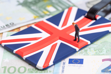 Europe, Brexit or Britain economy or financial concept, miniature figure businessman country leader standing on Union Jack UK national flag on pile of Euro banknotes money.の写真素材