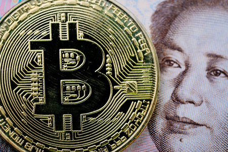 Bitcoin crypto currency, digital money in China concept, closed up shot of physical coin with B sign alphabet on face of Chinese yuan banknote.の写真素材