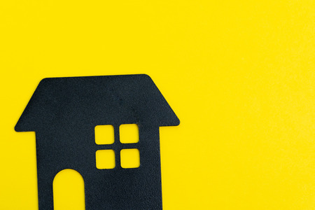 Decoration black house shape on solid yellow background with copy space using as happy home, good living and lifestyle or buy and sell new house concept.の写真素材