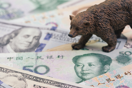 US and China trade war and tariff impact to bear market, price drop in stock concept, bear figure walking on pile of United States and Chinese banknotes, world most financial influence countries.の写真素材