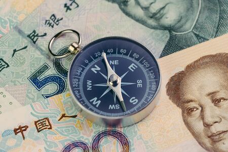 China financial and economics direction concept, compass on Chinese yuan banknotes.の写真素材