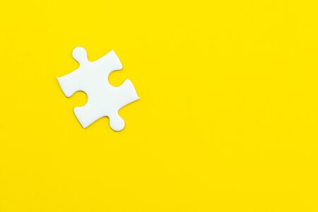 Last only one missing jigsaw puzzle on solid yellow background using as important thing combine or working together to success or solve problem.の写真素材