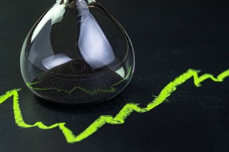 Time for invest or long term investment concept, hourglass or sandglass with black sand inside on...