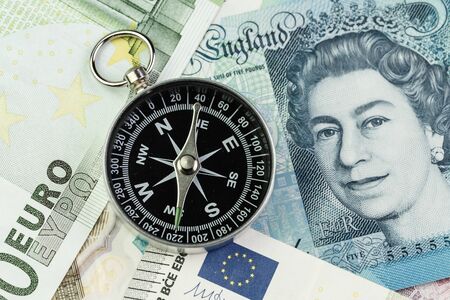 Direction of Europe and UK after Brexit negotiation concept, compass on Euro and UK Pound banknotes.の写真素材