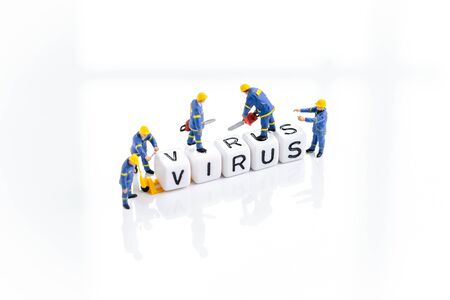 Miniature people men in blue uniform building the cube block with alphabets combine the word Virus using as Coronavirus flu treatment, illness from virus or medical and healthcare concept.の写真素材