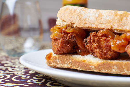 Breakfast sandwich with meat and onion in a plate with juice backgroundの写真素材