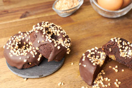 Cocoa donuts with almonds and nuts in a black and brown background horizontalの写真素材