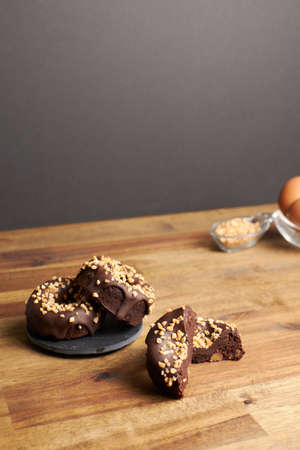Cocoa donuts with almonds and nuts in a black and brown background verticalの写真素材