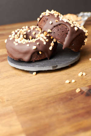 Cocoa donuts with almonds and nuts in a black and brown background verticalの写真素材