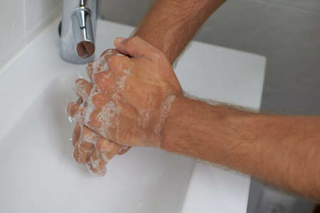 Hand washing with soap in a bathroomの写真素材