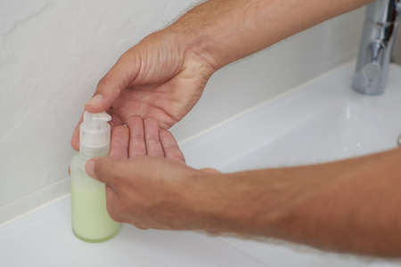 Hand washing with soap in a bathroom