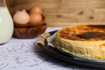 A creamy cheesecake with eggs and milk on brown and white backgroundの写真素材