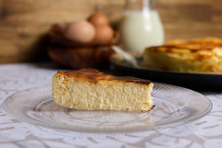 A creamy cheesecake with eggs and milk on brown and white backgroundの写真素材