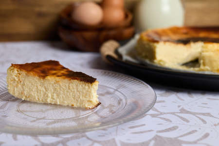 A creamy cheesecake with eggs and milk on brown and white backgroundの写真素材