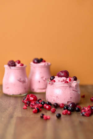 Berries foam dessert in orange and wood backgroundの写真素材