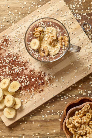 Healthy smoothie with banana and cocoa in brown backgroundの写真素材