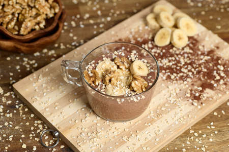 Healthy smoothie with banana and cocoa in brown backgroundの写真素材