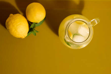 Fresh lemonade on a yellow background with lemons and mintの写真素材