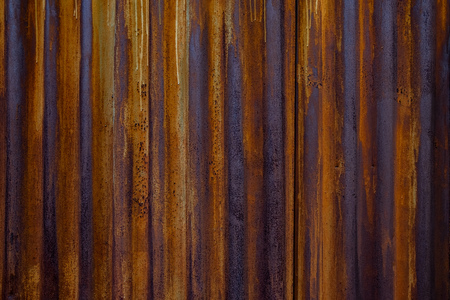 Old corrugated iron sheet of brown color with numerous traces of rust