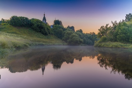 Church on the river at sunriseの写真素材
