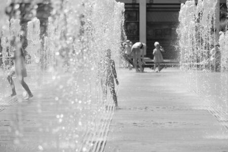 Moscow. Russia. June 19, 2019. Children bathing in a refreshing spray of the city fountain on a hot...