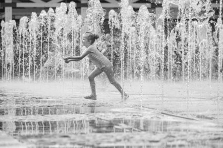 Moscow. Russia. June 19, 2019. Children bathing in a refreshing spray of the city fountain on a hot summer day.のeditorial素材