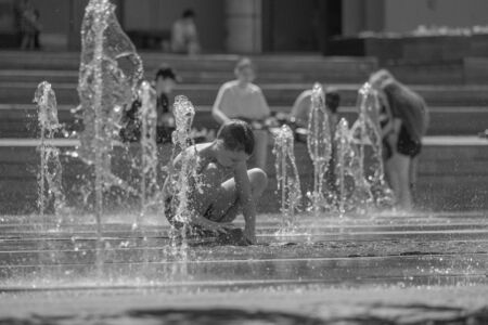 Moscow. Russia. June 19, 2019. Children bathing in a refreshing spray of the city fountain on a hot summer day.のeditorial素材