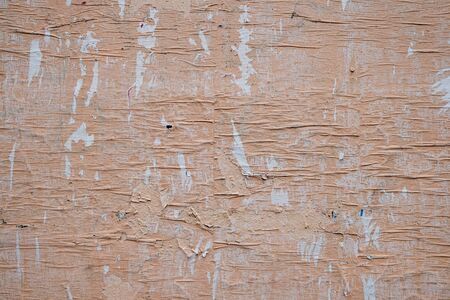 The surface is pasted over with wrinkled paper, painted with a pale pink paint. Grunge background.