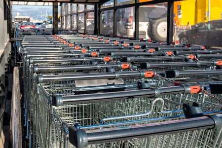 Rows of shopping trolleys with pay system. Attribute of a supermarket and a supermarket in a metropolis. The object of urban life.の写真素材
