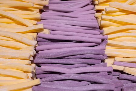 Long sticks of chewing marmalade lie in rows in a store counter. Beautiful tasty treat made from natural ingredients.の写真素材