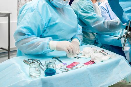 Sterile surgical instruments and glass containers with solutions on the table during a surgical...