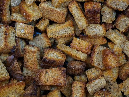 Selective focus on slices of fried rye bread close-up. Tasty ruddy rye croutons with vegetable oil and salt. Abstract food background.の写真素材