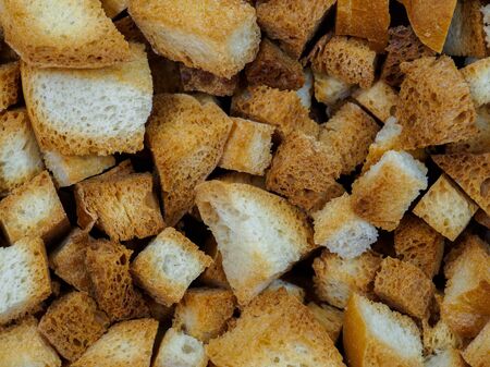 Selective focus on slices of fried white bread close-up. Tasty rosy croutons. Abstract food...