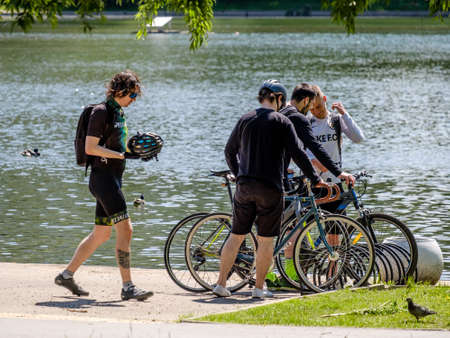 Moscow, Russia. June 14, 2020. Male athletes on the shore of a city reservoir with bicycles. Summer...