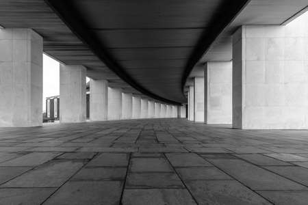 A smoothly curved gallery with rectangular vertical light columns of stone.