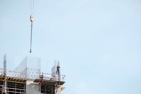 Moscow. Russia. September 06, 2020 View of the construction of a monolithic house against the background of the sky. A tower crane and uniformed workers assembling a reinforcing steel structureのeditorial素材