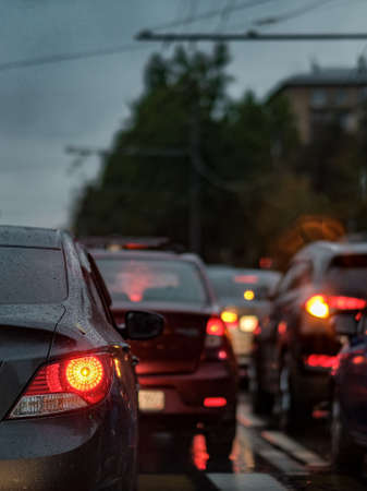 Moscow. Russia. September 08, 2020 Selective focus on the parking light of a car standing in a traffic jam in the rain. Dusk. Raindrops on the car body. Blurred backgroundのeditorial素材