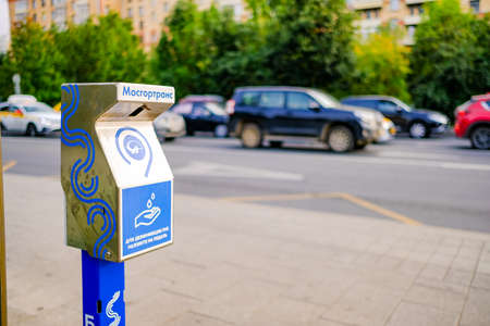Moscow. Russia. September 04, 2020 A device for non-contact hand disinfection at a public transport stop on the roadway with moving vehicles. Modern technologies that protect people from infection.のeditorial素材