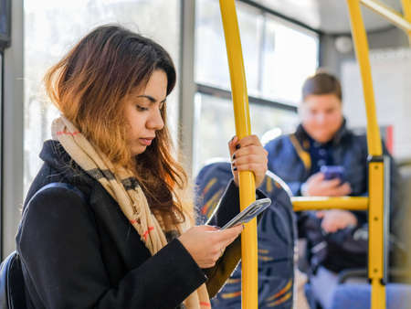 Moscow. Russia. September 16, 2020. A young, dark-haired girl stands on the bus with a smartphone in...