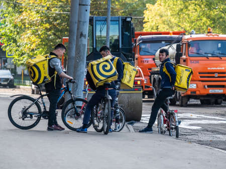 Moscow. Russia. October 4, 2020. A group of male delivery service men on bicycles stand on a city street.のeditorial素材