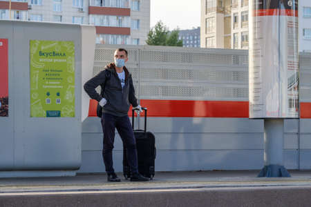 Moscow, Russia. October 4, 2020. A lonely man in a protective mask and gloves with a suitcase at the...