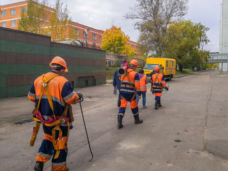 Moscow. Russia. October 7, 2020. Workers in orange uniforms and helmets are walking down the street...