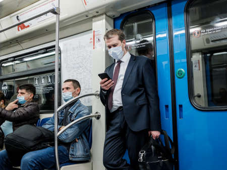 Moscow. Russia. October 5, 2020 A man in a subway car is looking at his smartphone with enthusiasm.のeditorial素材