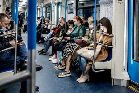 Moscow. Russia. October 5, 2020. A young woman with a protective mask on her face stands in a subway car.のeditorial素材