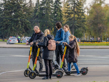 Moscow. Russia. October 11, 2020 Parents and daughter enjoy an electric scooter ride on a sunny autumn day.のeditorial素材