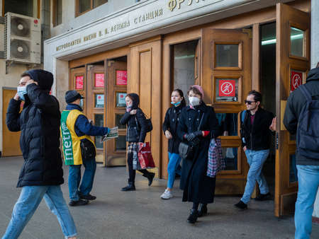 Moscow. Russia. October 28, 2020 A man wearing a face mask and uniform distributes newspapers to...